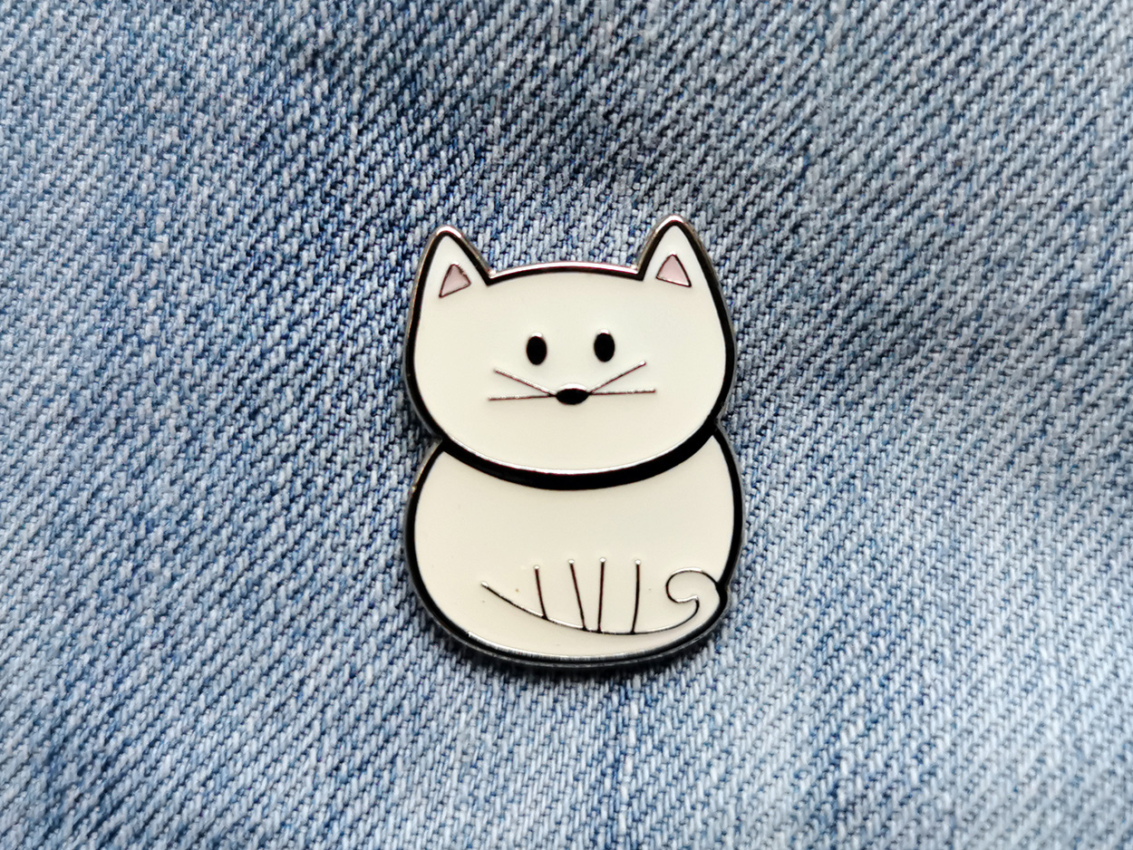 A Cute Cat enamel pin.