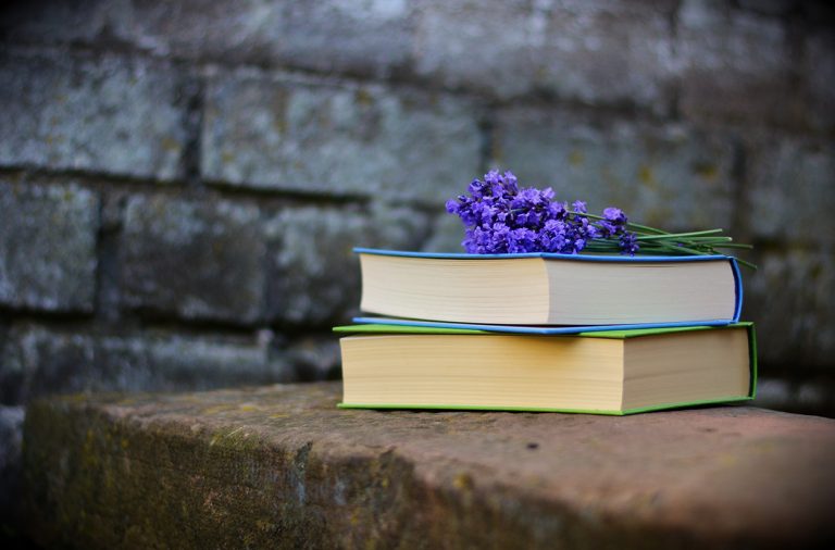 Two books with flowers on top.
